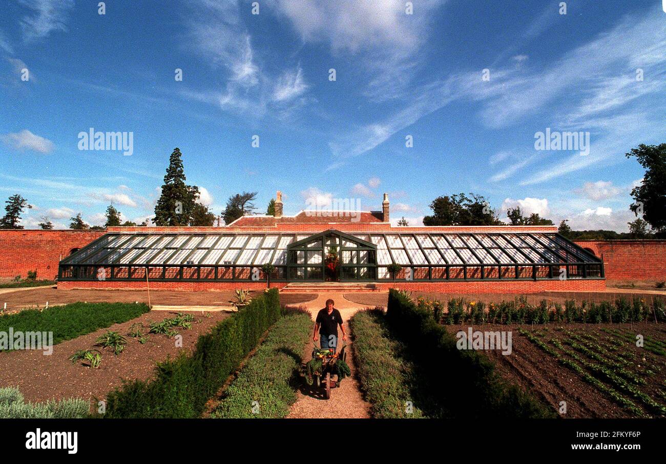 The National Trust has just completed a restoration Aug 2000of the walled garden at Wimpole Hall, including re-building the glasshouses to the original design of the 18th century architect Sir John Soane  they were destroyed by a german bomb in World War Two. Head gardener Philip Whaites pushing his wheelbarrow Stock Photo