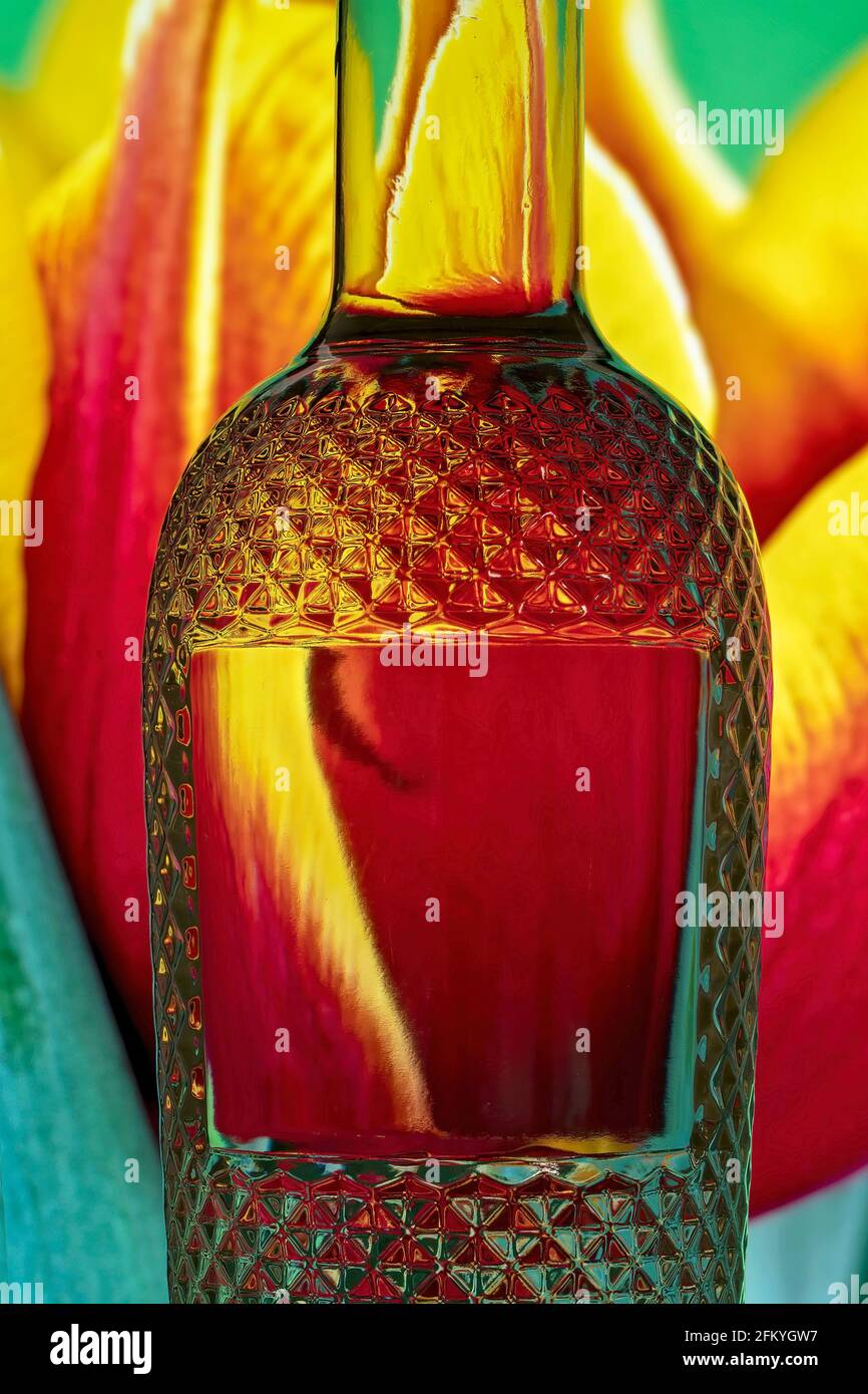Light refraction caused by light traveling through glass filled with water and reflecting its colorful background. Stock Photo