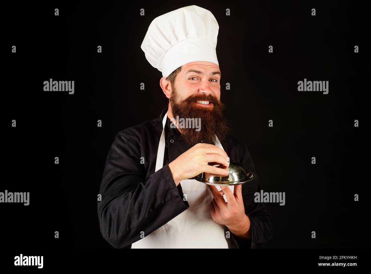 Restaurant serving and presentation. Male chef with food tray. Cook with cloche in restaurant. Stock Photo