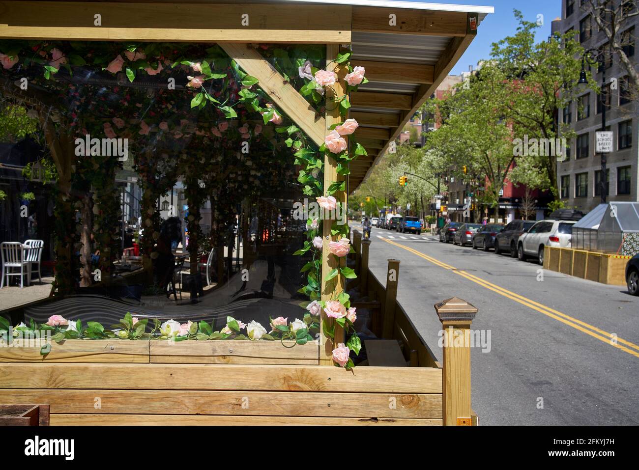 Temporary, COVID-19 regulated outdoor sidewalk cafe and restaurant decorated with flowers in New York City. Stock Photo