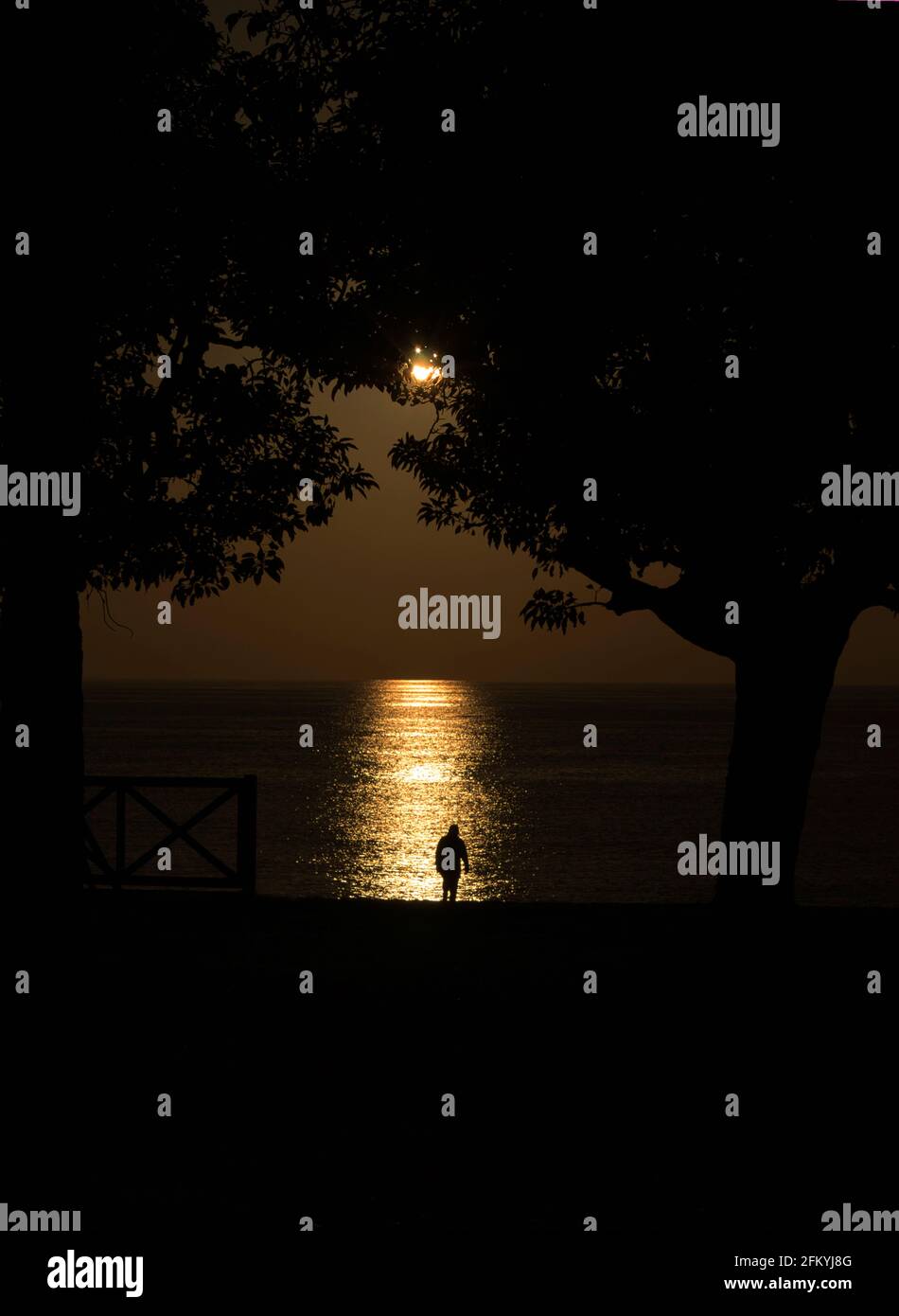 silhouette of a man on the beach against the ocean at sunset Stock ...