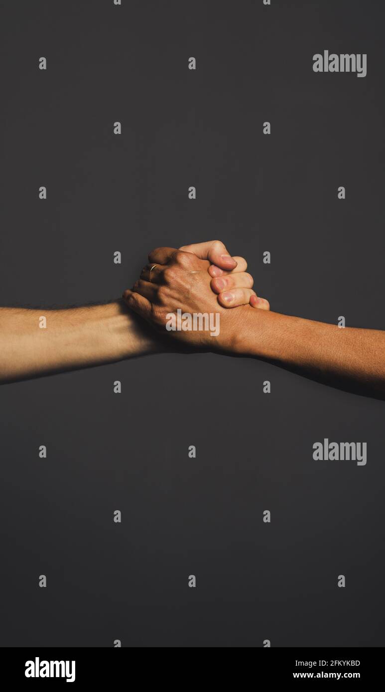 Vertical shot of a pair of hands griping each other in the G lock