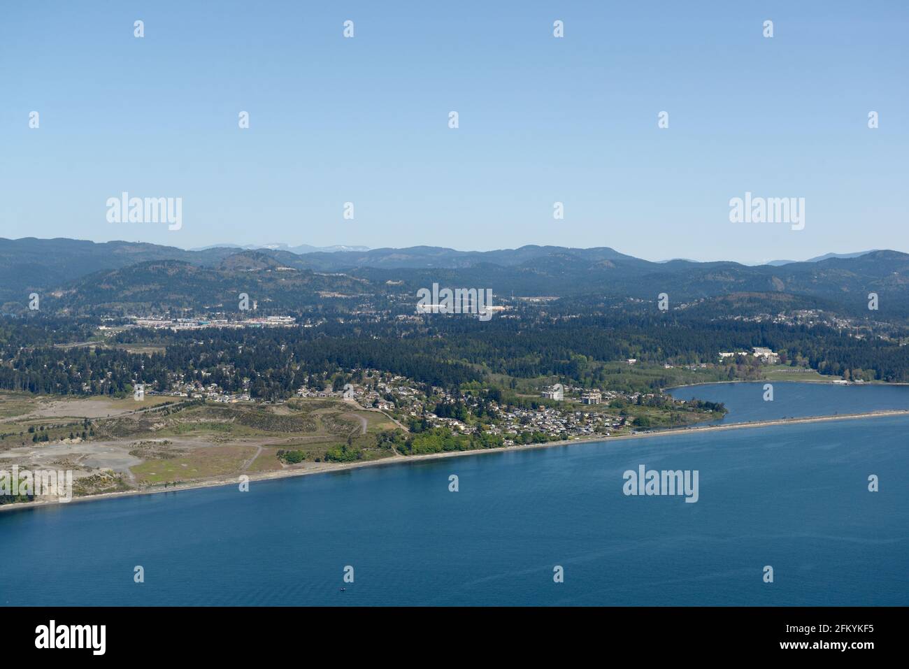 Aerial photo of the gravel pit and Esquimalt Lagoon and Colwood. Royal Roads University is located at the back of the lagoon, Vancouver Island, Britis Stock Photo