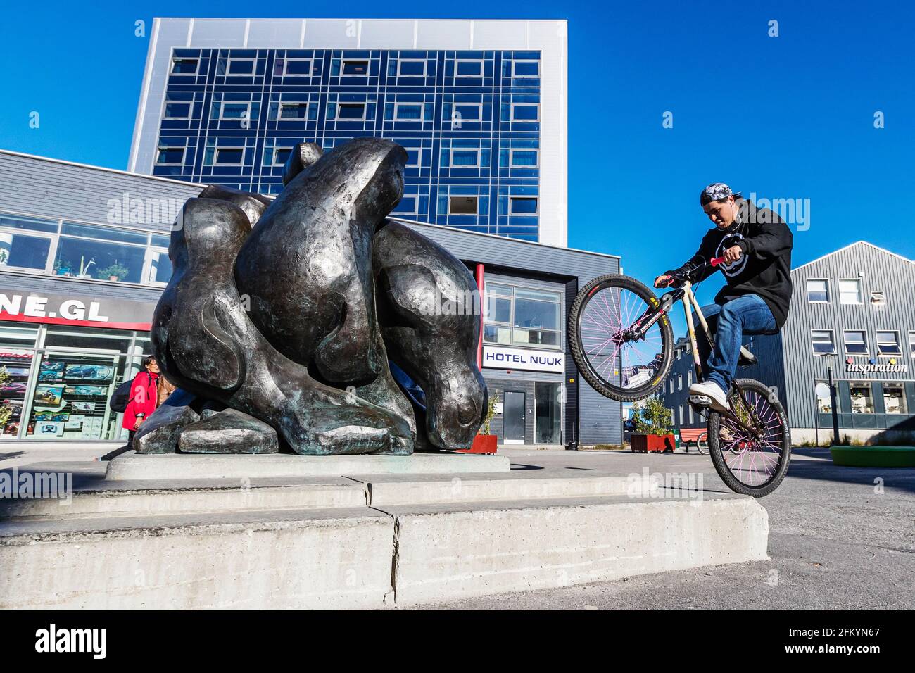 Young man on bicycle in downtown Nuuk, or Godthåb, the Capital and the largest city in Greenland. Stock Photo