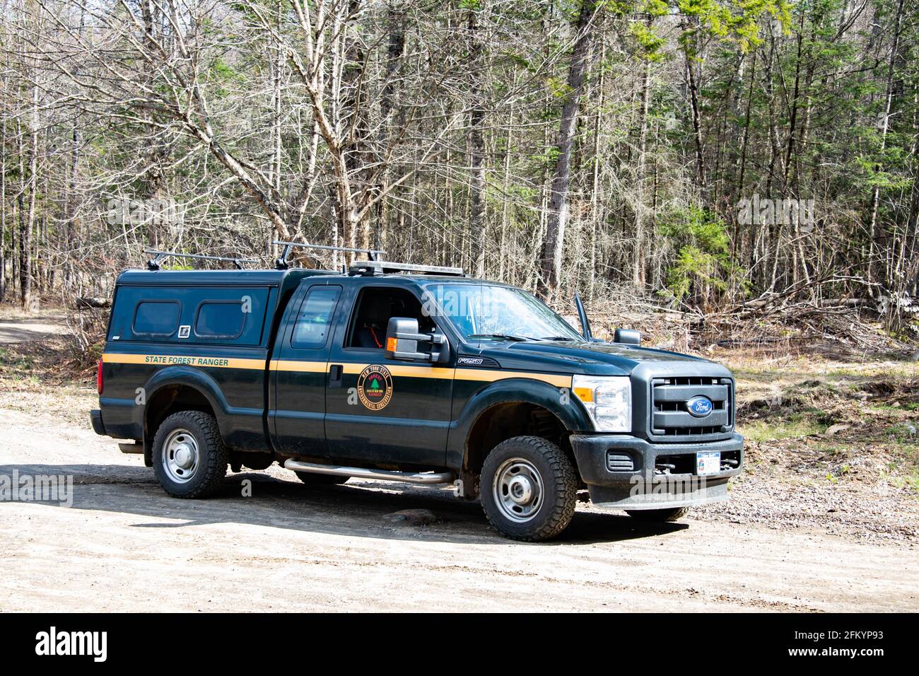 A New York State Department of Environmental Conservation Forest Ranger pickup truck parked on a dirt road in the Adirondack Park wilderness. Stock Photo