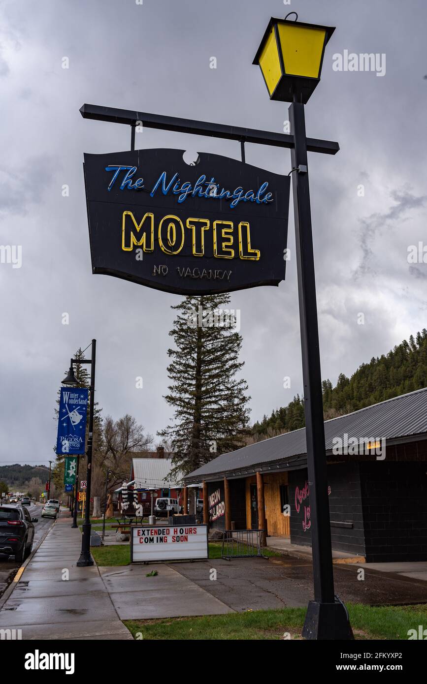 Sign for The Nightingale Motel hanging from an old fashioned lamp post, located on the main street in a small town, Pagosa Springs, Colorado.. Stock Photo