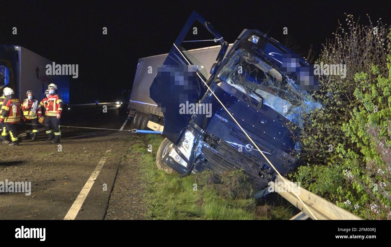 05 May 2021, Lower Saxony, Löningen: A truck is half in the ditch on the B213. Four trucks were involved in a serious accident on the federal highway. On Wednesday morning, the rescue work was still in progress, and the road was fully closed in both directions at the scene of the accident. Photo: NWM/dpa - ATTENTION: The references on the truck to the shipping company have been pixelated for legal reasons. Stock Photo