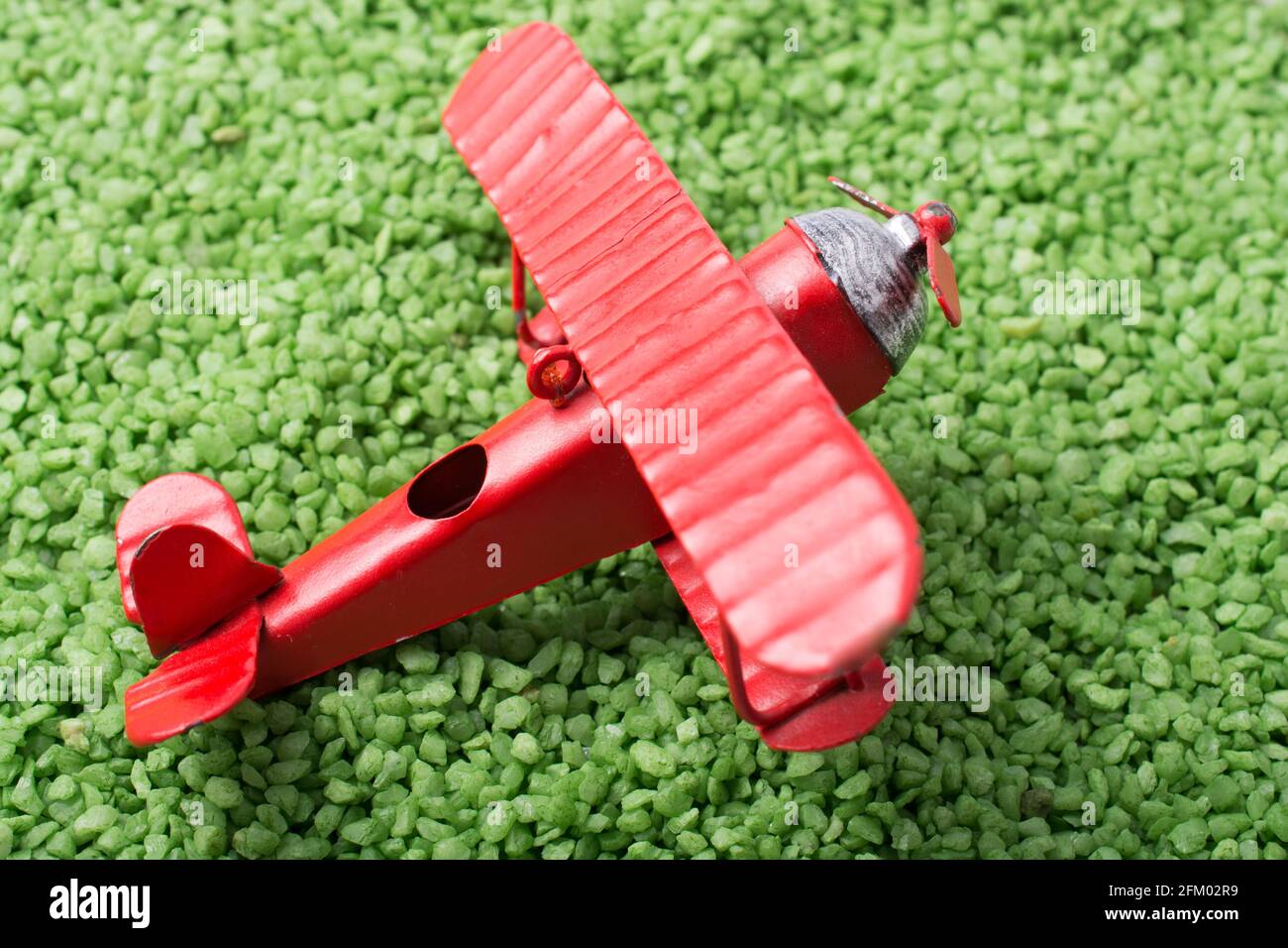 Red color toy plane is on a sand texture Stock Photo - Alamy
