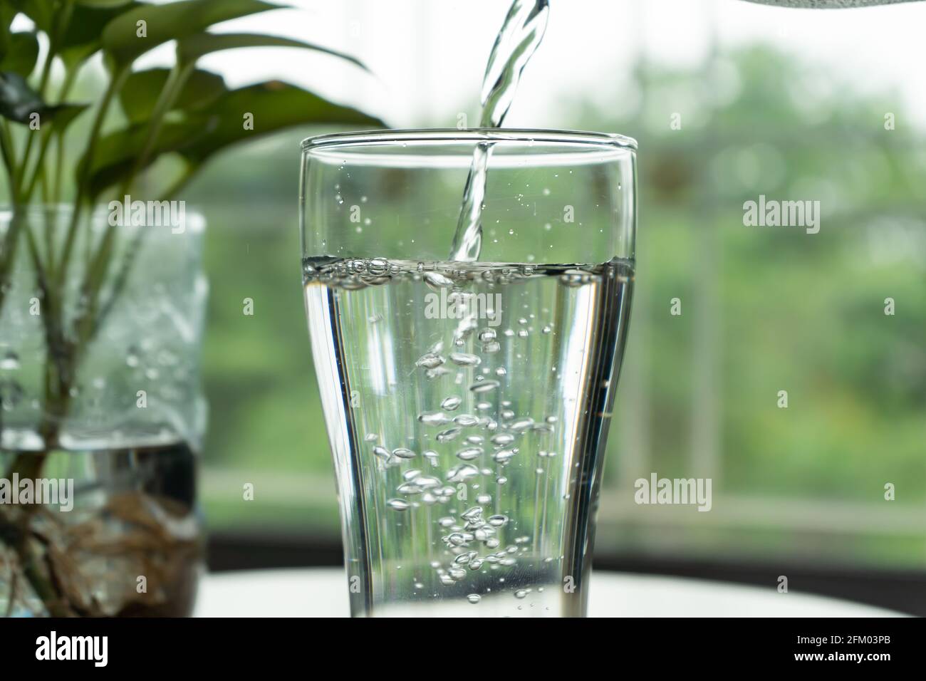Pouring water into a glass Stock Photo