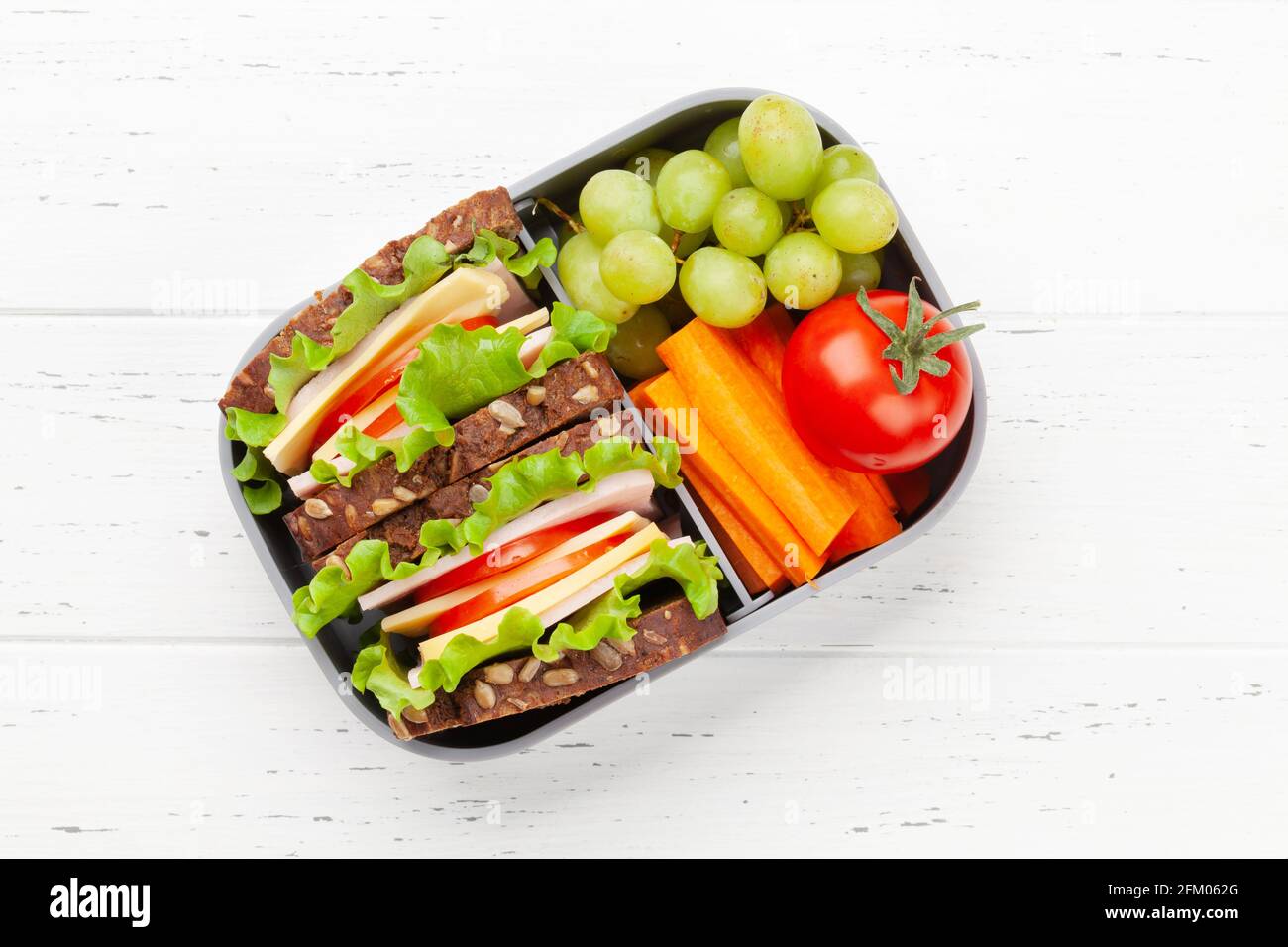 Healthy school lunch box with sandwich and fresh vegetables. Top view ...