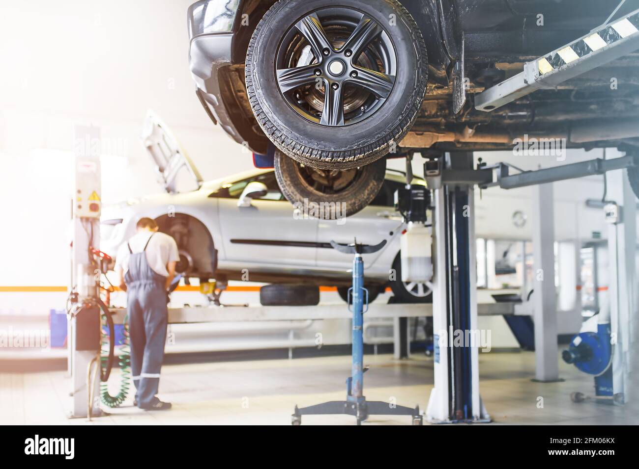 The car is lifted for repair on a lift in a car service station, a