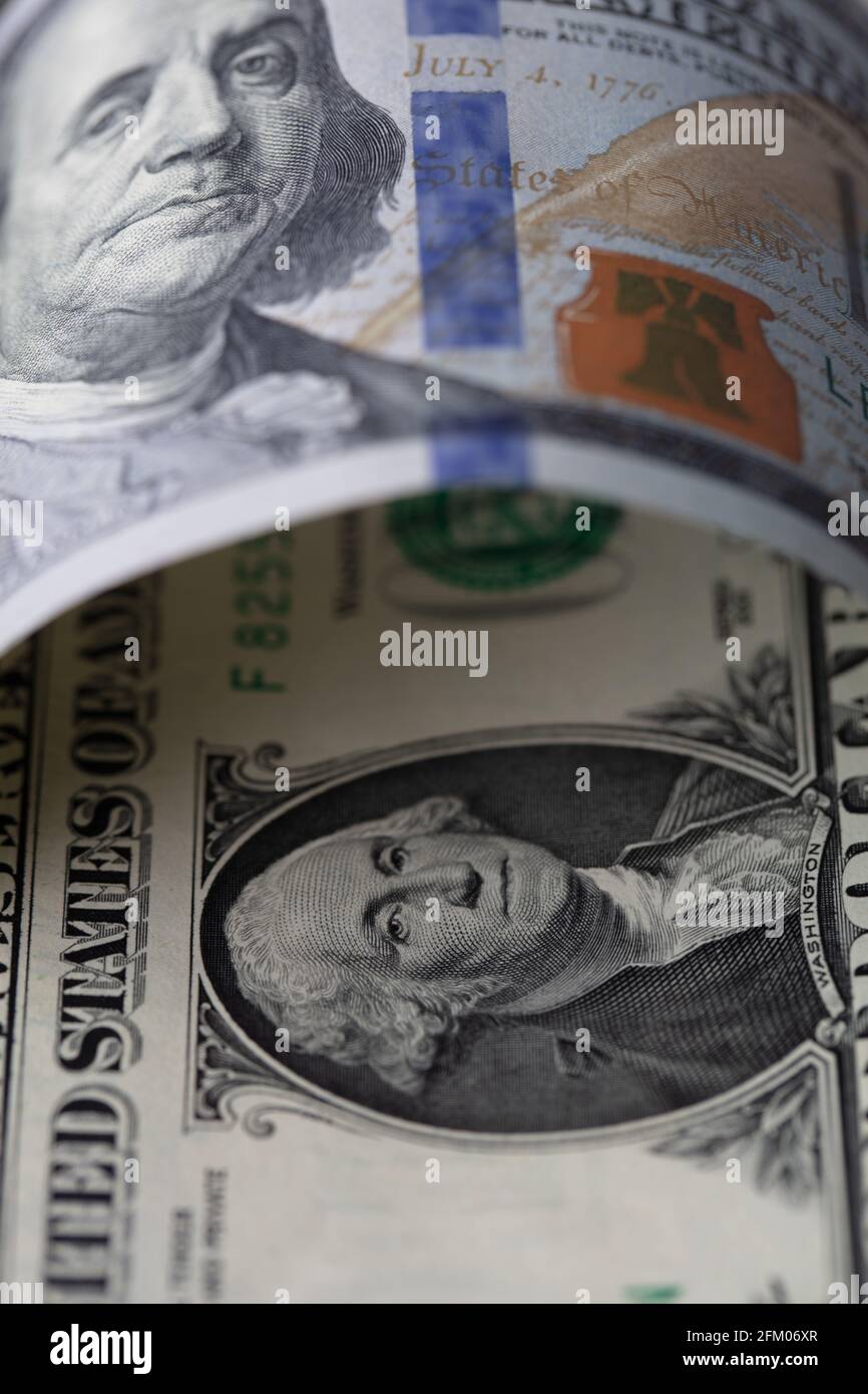 slightly rolled 100 dollar banknote over 1 dollar banknote for design ...