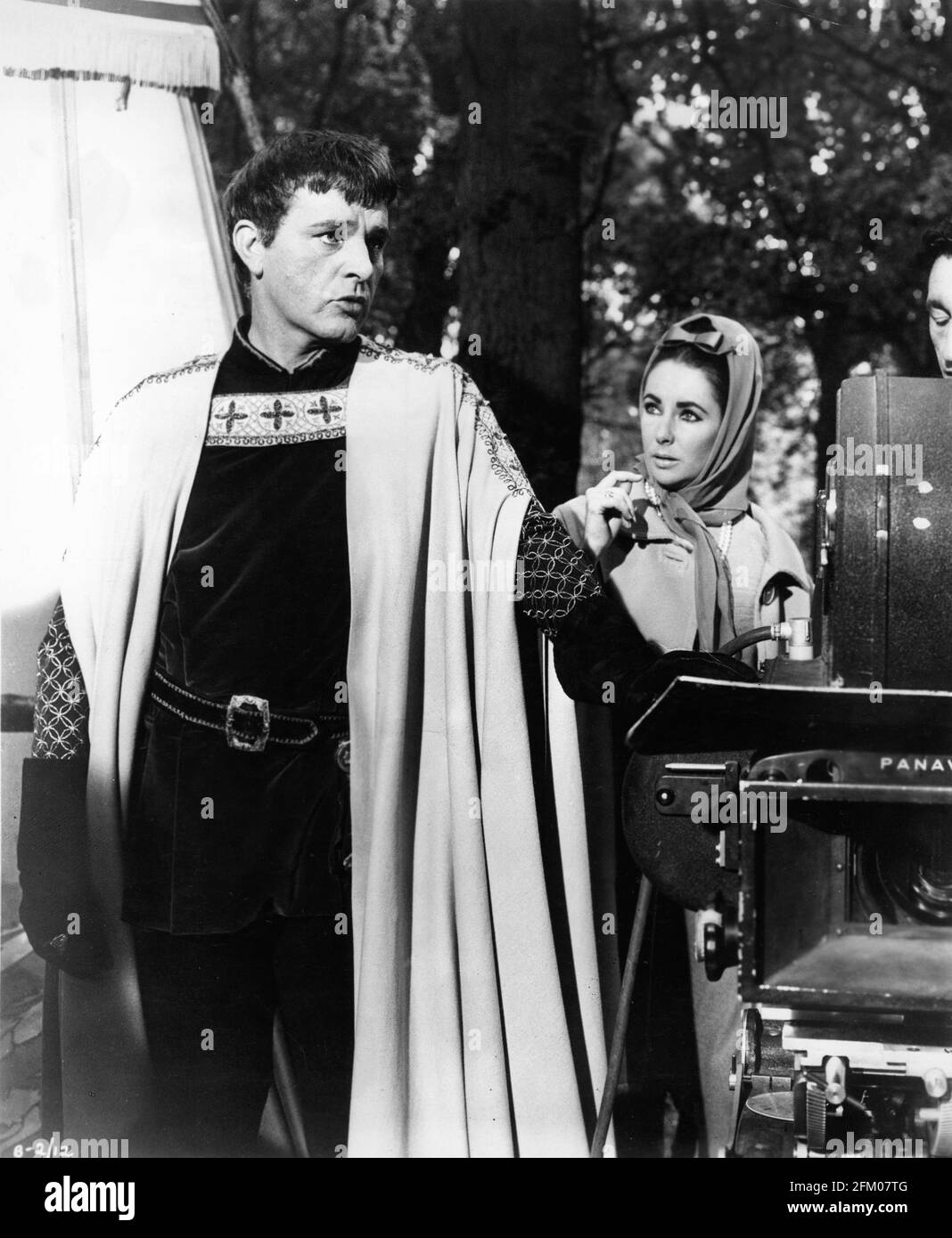 RICHARD BURTON with Set Visitor / Wife ELIZABETH TAYLOR on set candid during filming of BECKET 1964 director PETER GLENVILLE play Jean Anouilh and Lucienne Hill screenplay Edward Anhalt costume design Margaret Furse producer Hal B. Wallis  Wallis-Hazen A Paramount Film Service & Keep Films Co-Production / Paramount Pictures Stock Photo