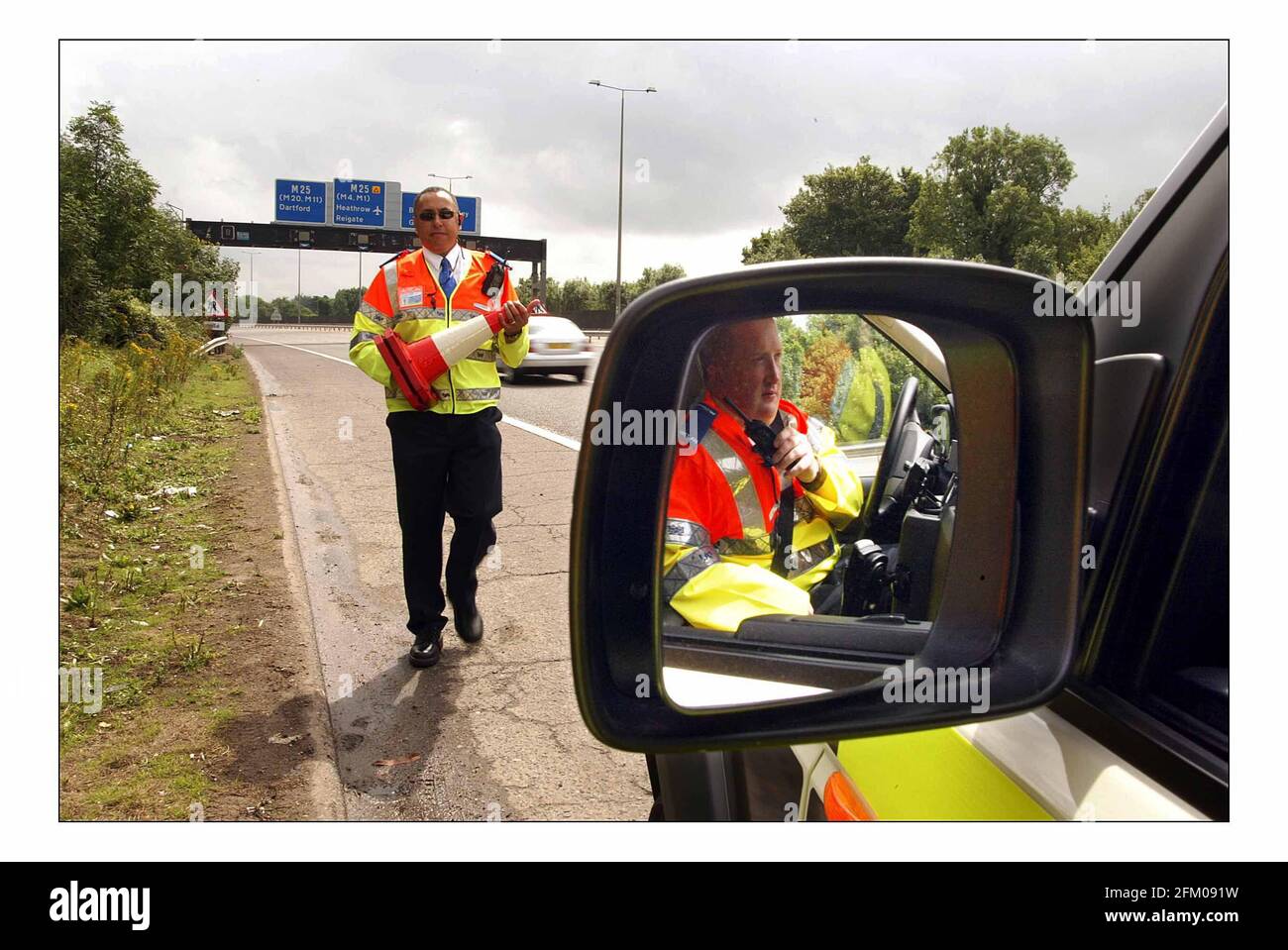 Jam Busting Patrols on M25......Working alongside the police, new Highways Agency Traffic Officers today start patrolling and monitoring the Surrey sections of the M25, M3 and the M 23 in highly visible vehicles. They will be managed from a new Regional Control Centre in Godstone. Officers Norman Jacobs (out of vehicle) and Chris Hogsden (driving) seen on the M23.pic David Sandison 1/8/2005 Stock Photo