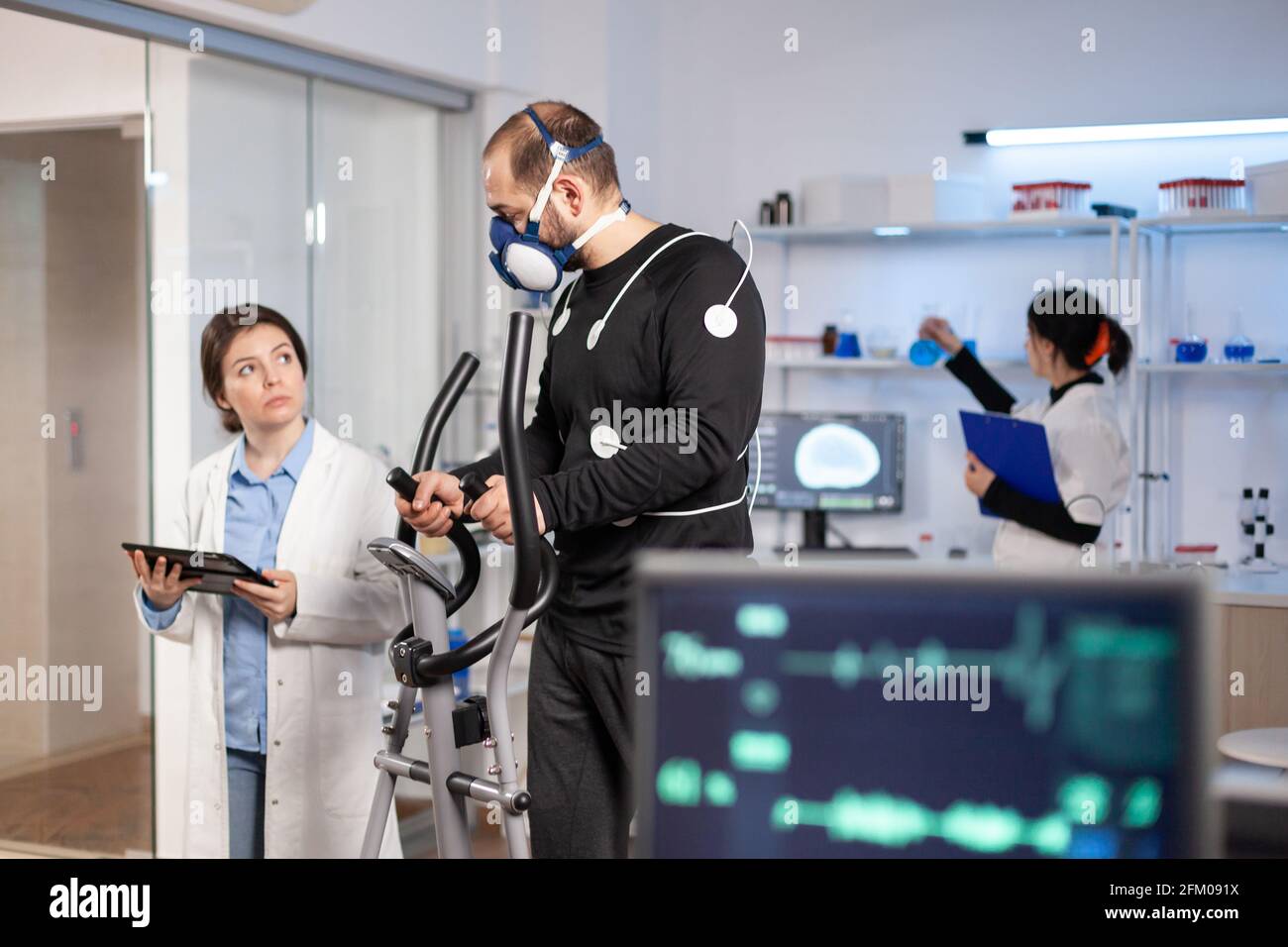 Sport scientist monitoring performance of athlete cardio, heart rate