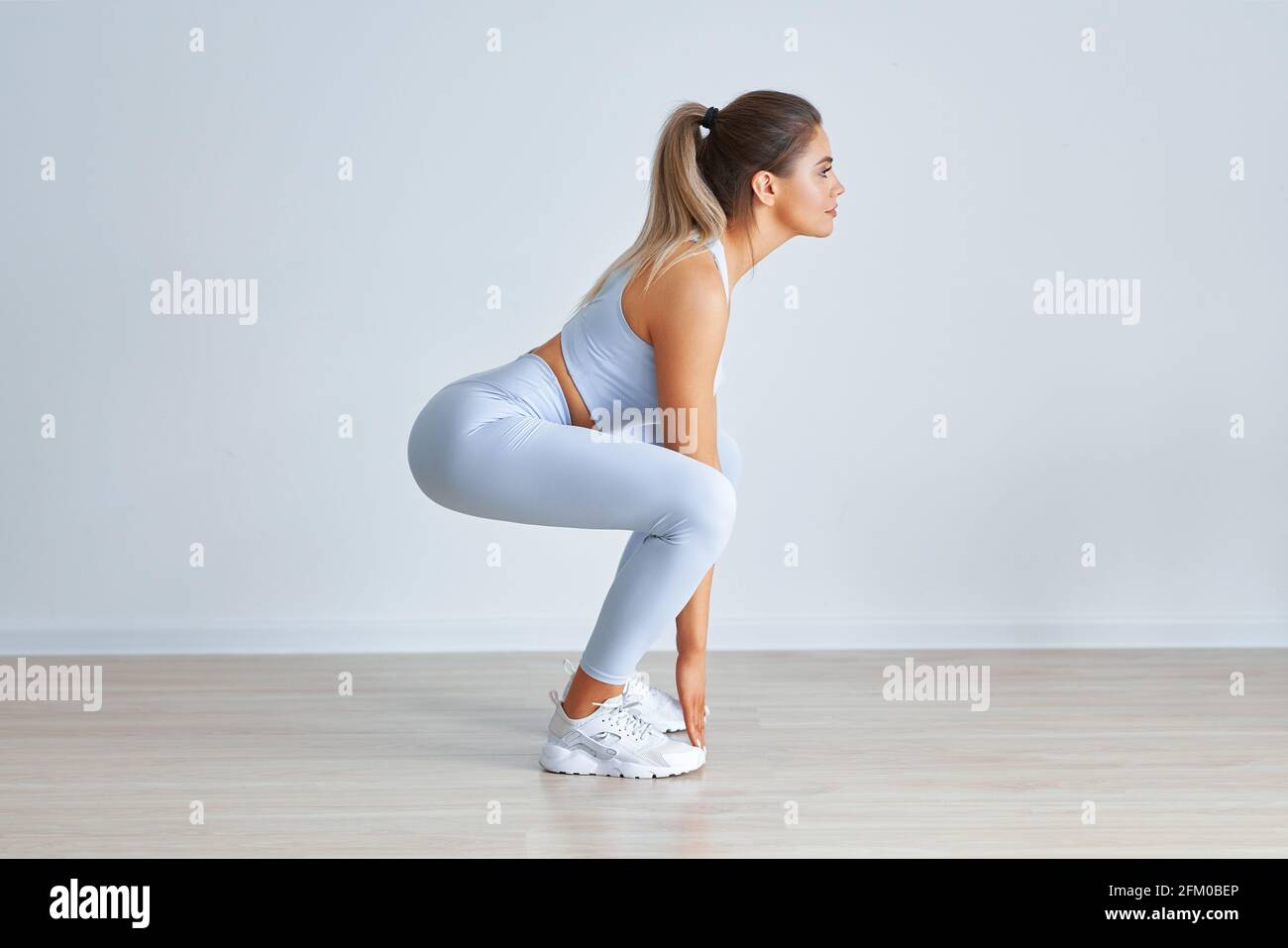 Adult beautiful woman working out over light background Stock Photo