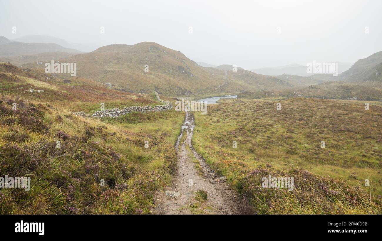 Hiking track among scenic moorland in Scottish Highlands at rainy autumnal day Stock Photo