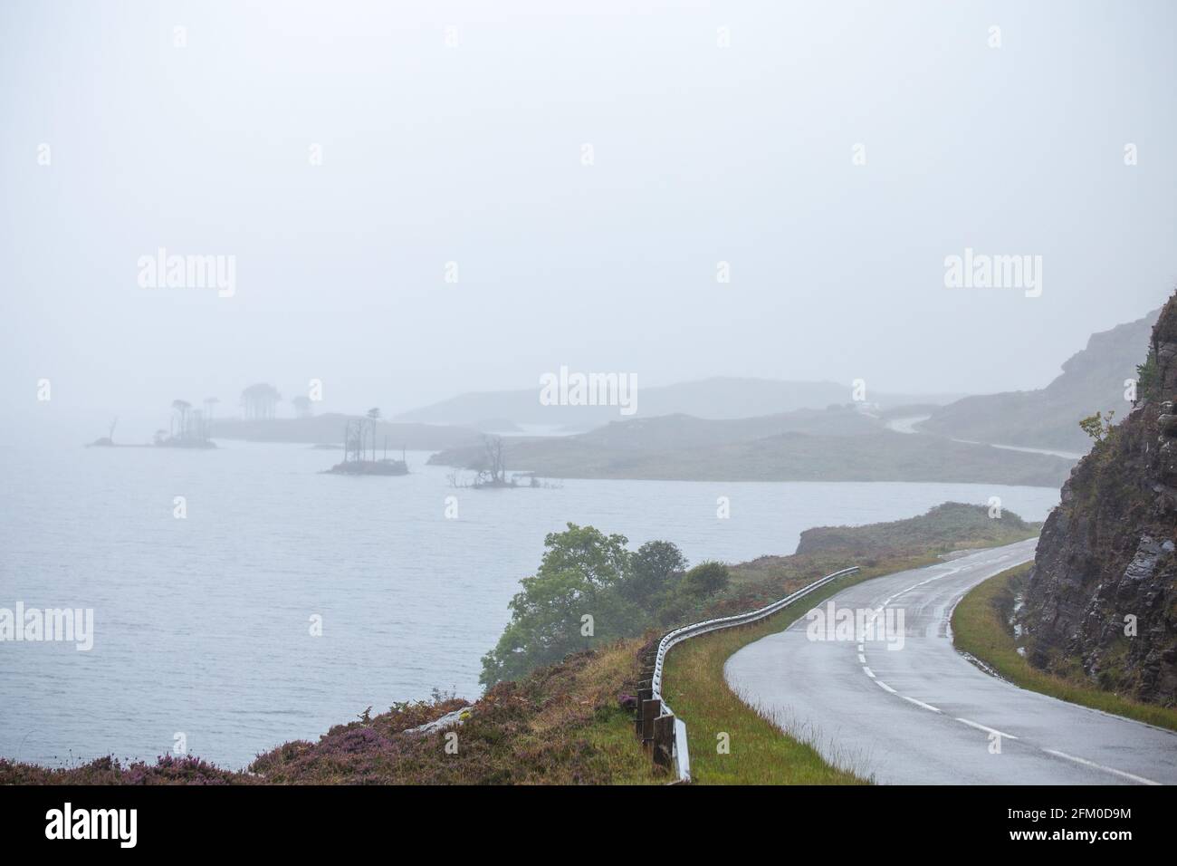 Empty asphalt road across scenic landscape of Scottish Highlands at rainy autumnal day Stock Photo