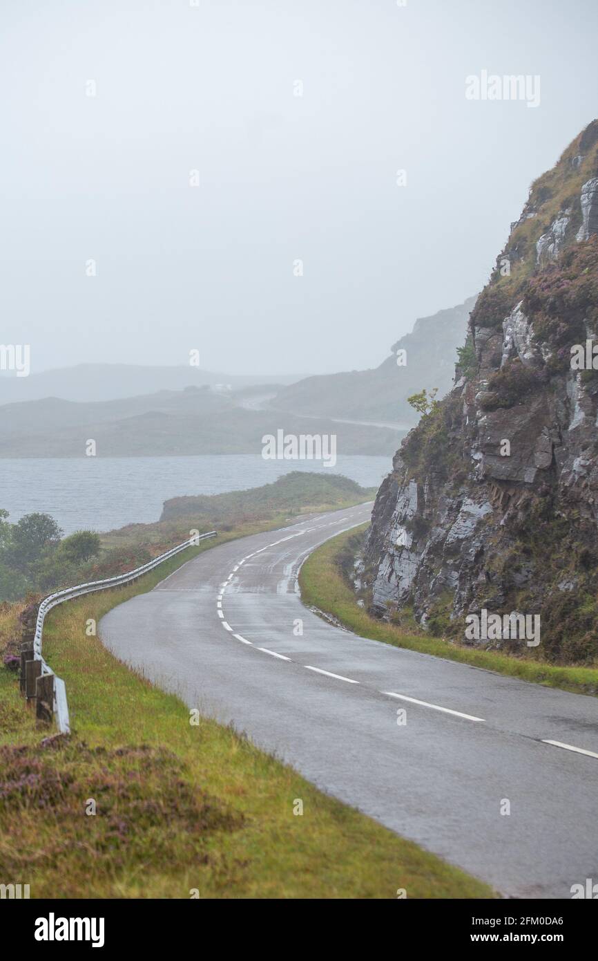 Empty asphalt road across scenic landscape of Scottish Highlands at rainy autumnal day Stock Photo