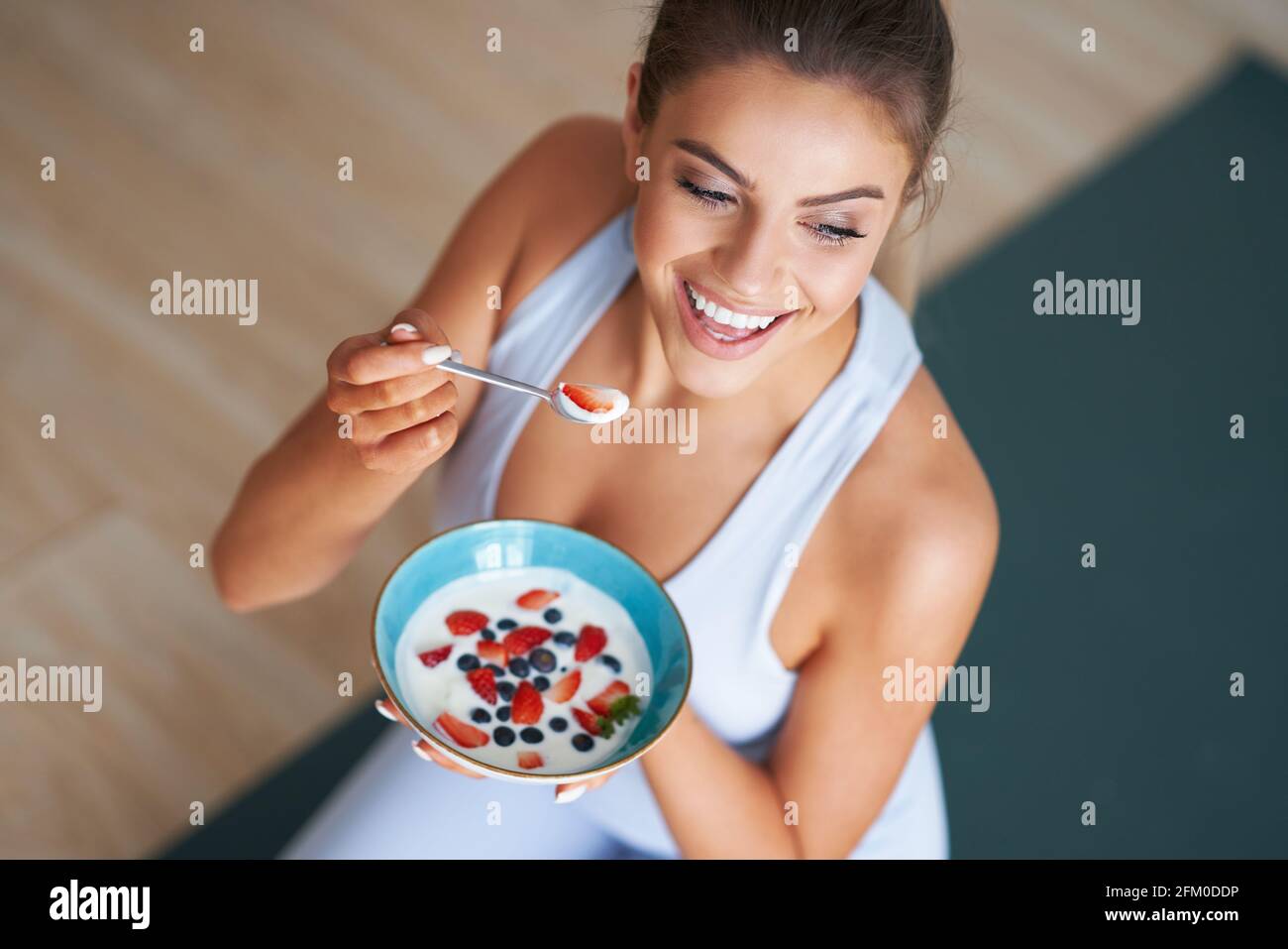 Portrait of beautiful hispanic woman eating yoghurt promoting healthy lifestyle Stock Photo