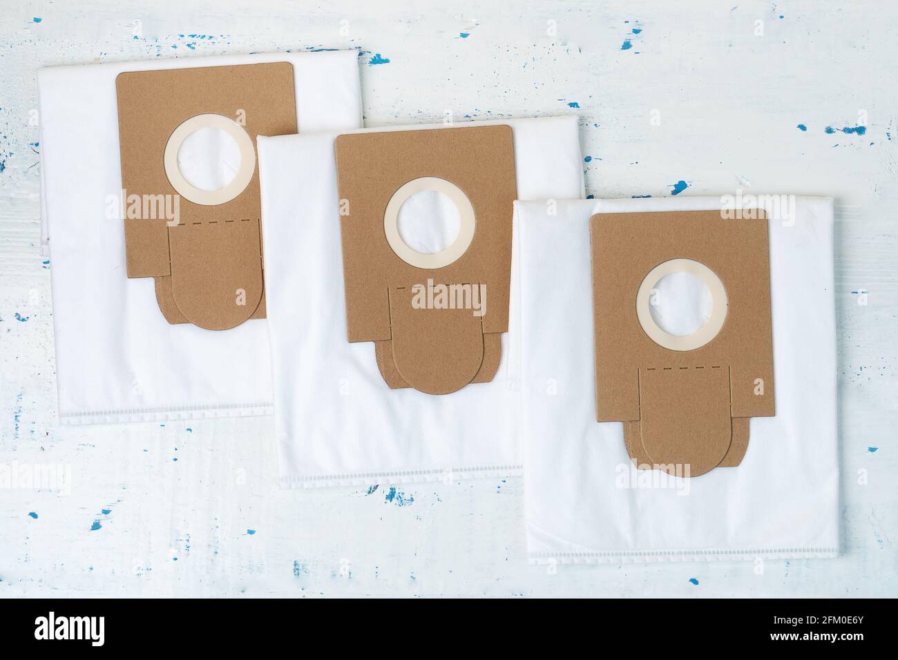 New empty dust bags for a vacuum cleaner lying on the painted wooden