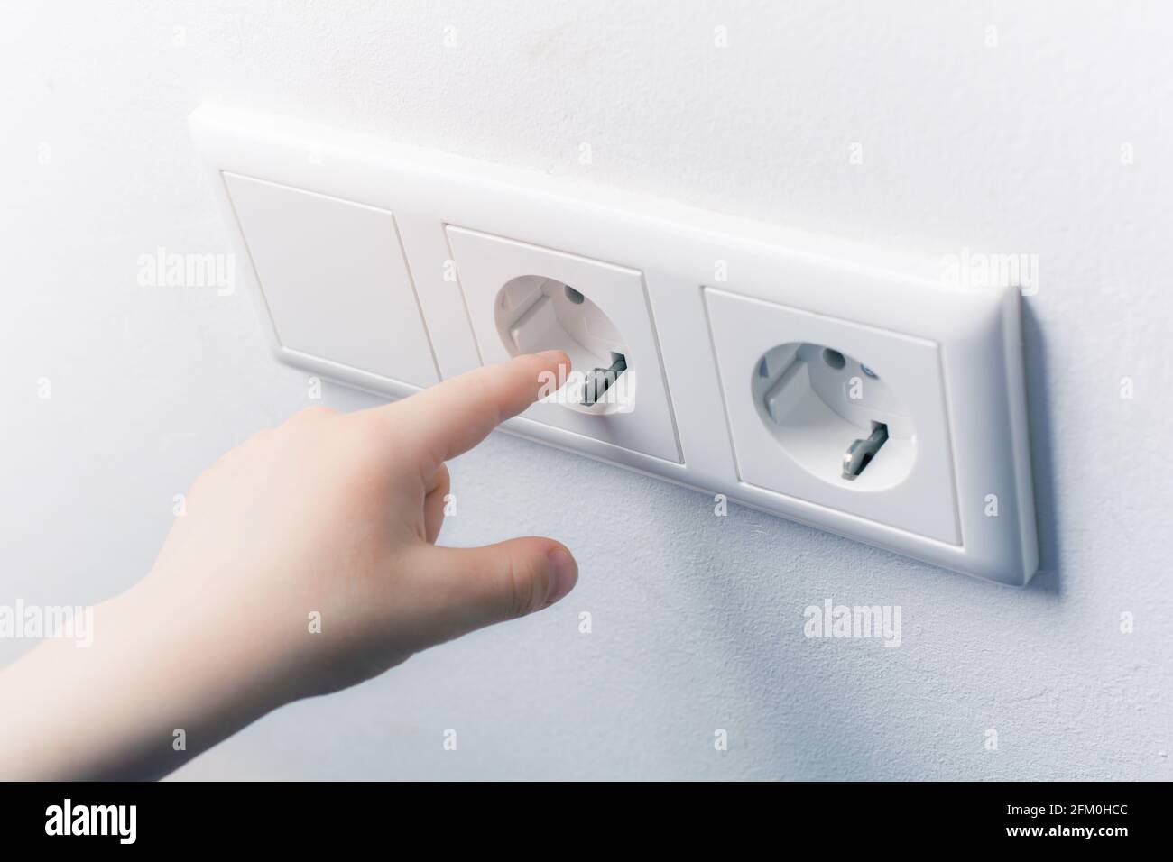 Child Tries To Touch A Wall Socket Without Safety Plugs Prevent Child