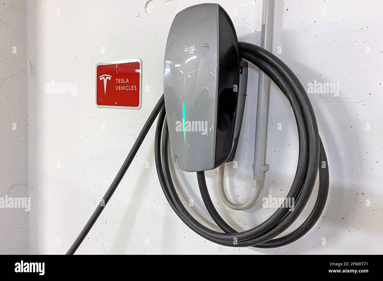 Munich, Germany. 05th May, 2021. Wall box for charging an e-car, electric  car, e-car is being charged, charging plug, charging cable, box, charger  hangs on the wall in a parking garage, charging