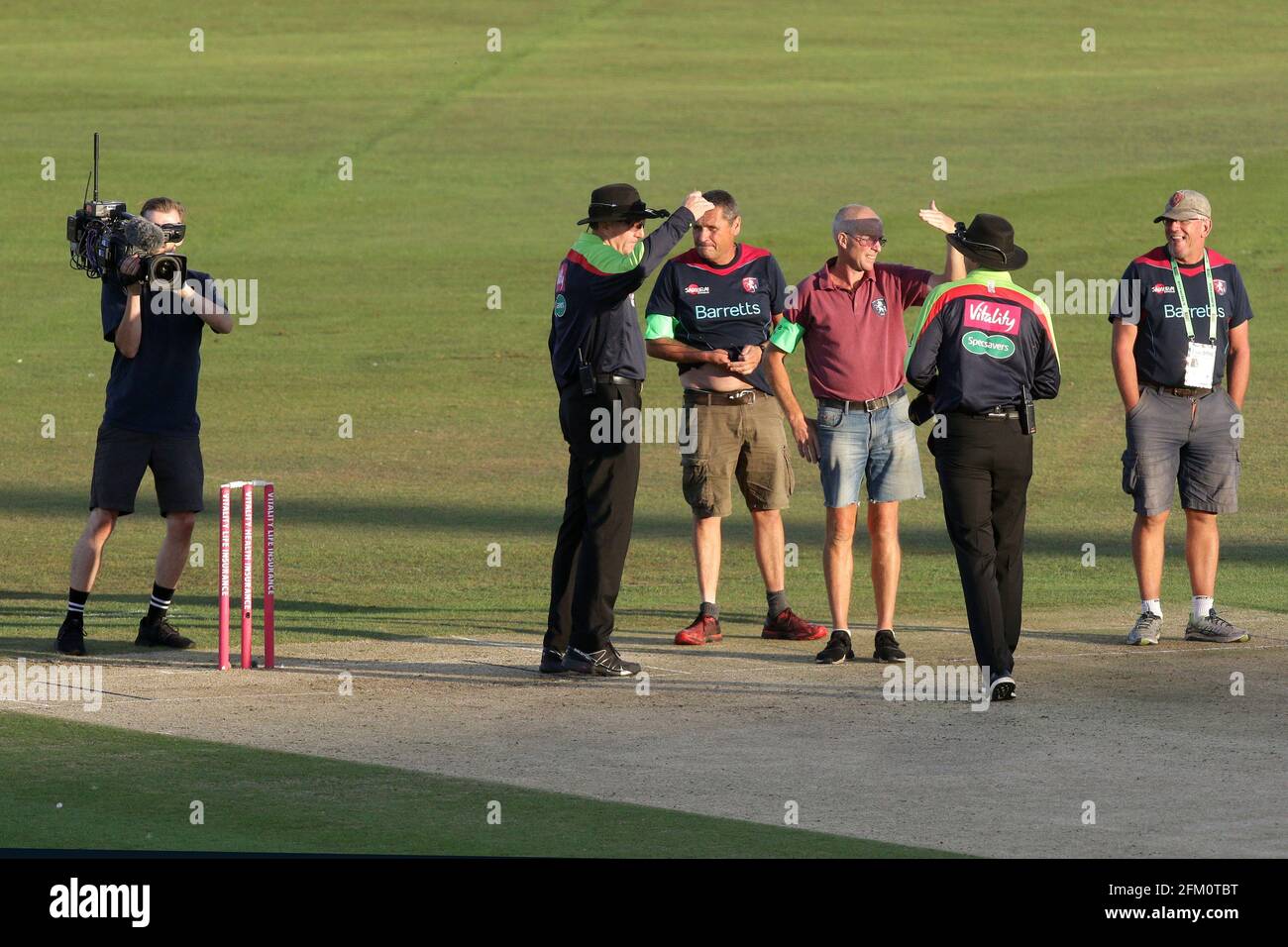 Umpires Rob Bailey and Mike Burns speak to the ground staff as the low sun causes play to be suspended during Kent Spitfires vs Essex Eagles, Vitality Stock Photo