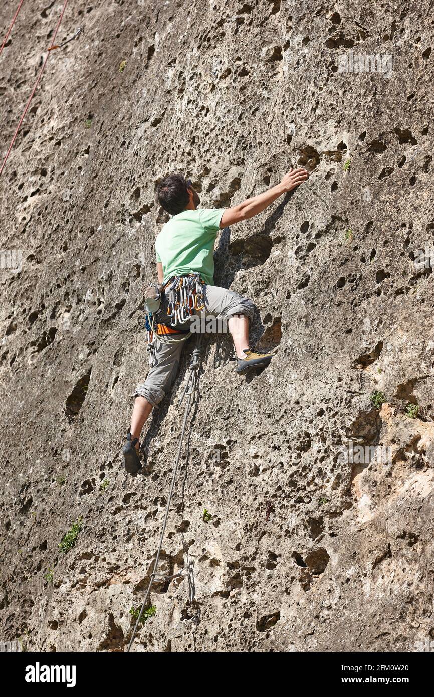 Rock climber with essential gear on granite wall showcasing proper equipment for outdoor climbing adventures