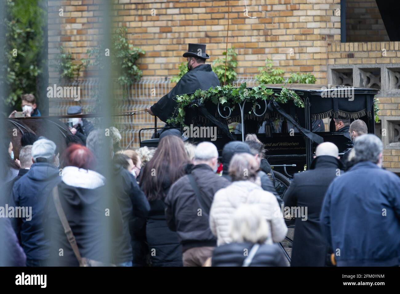 Cologne, Germany. 05th May, 2021. 05 May 2021, North Rhine-Westphalia, Cologne: The coffin with the mortal remains of Willi Herren is driven to the grave at the Melaten cemetery by a funeral home in a carriage. The actor and singer Willi Herren had died on April 20. Credit: dpa picture alliance/Alamy Live News Stock Photo