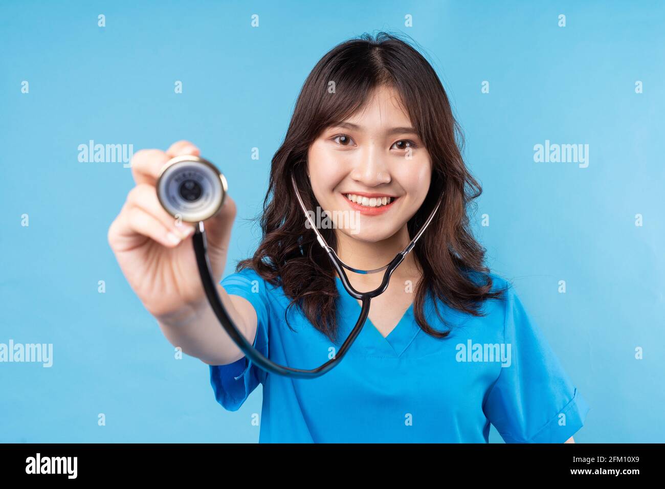 Young Asian female doctor need stethoscope laughing happily on background Stock Photo