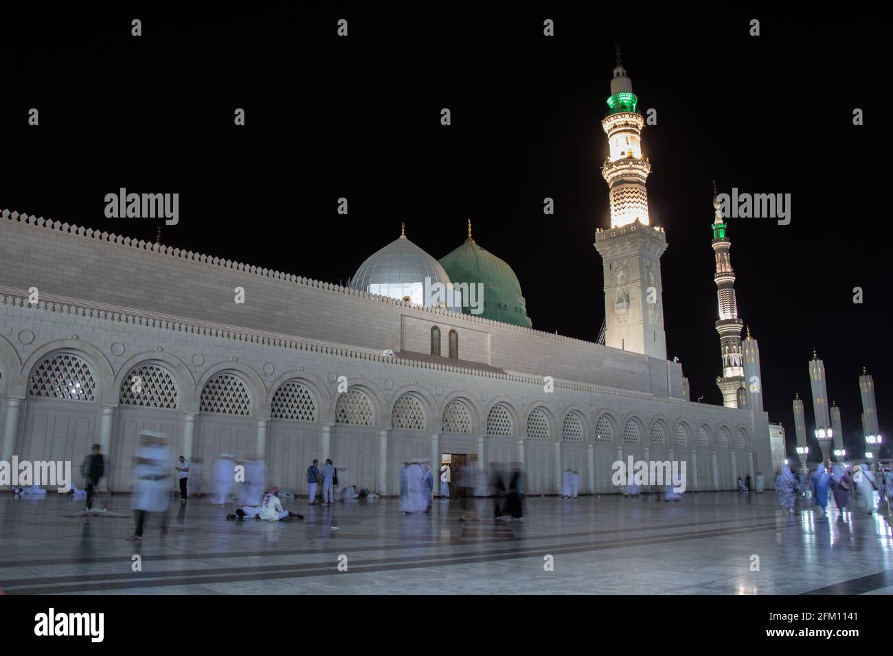 Masjid Nabawi at night time. People walking at night at the Prophet's Mosque in Medina Stock Photo