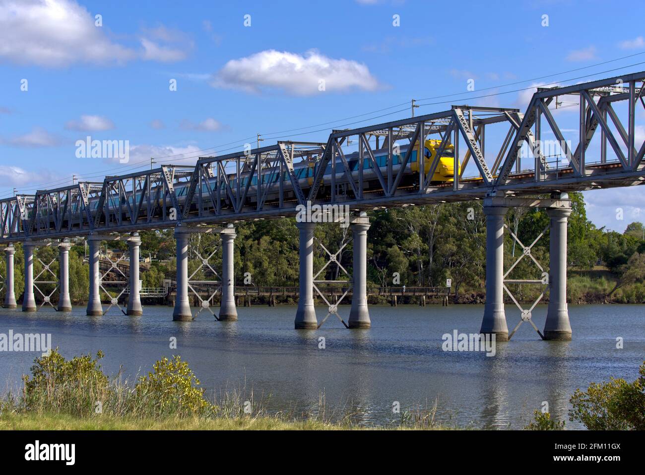 Queensland Rail tilt train crossing the River railway bridge