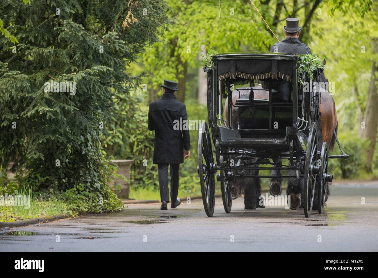 Cologne, Germany. 05th May, 2021. A horse-drawn carriage arrives for Willi Herren's funeral service at Melaten Cemetery. The actor and singer Willi Herren had died on April 20. Credit: Rolf Vennenbernd/dpa/Alamy Live News Stock Photo