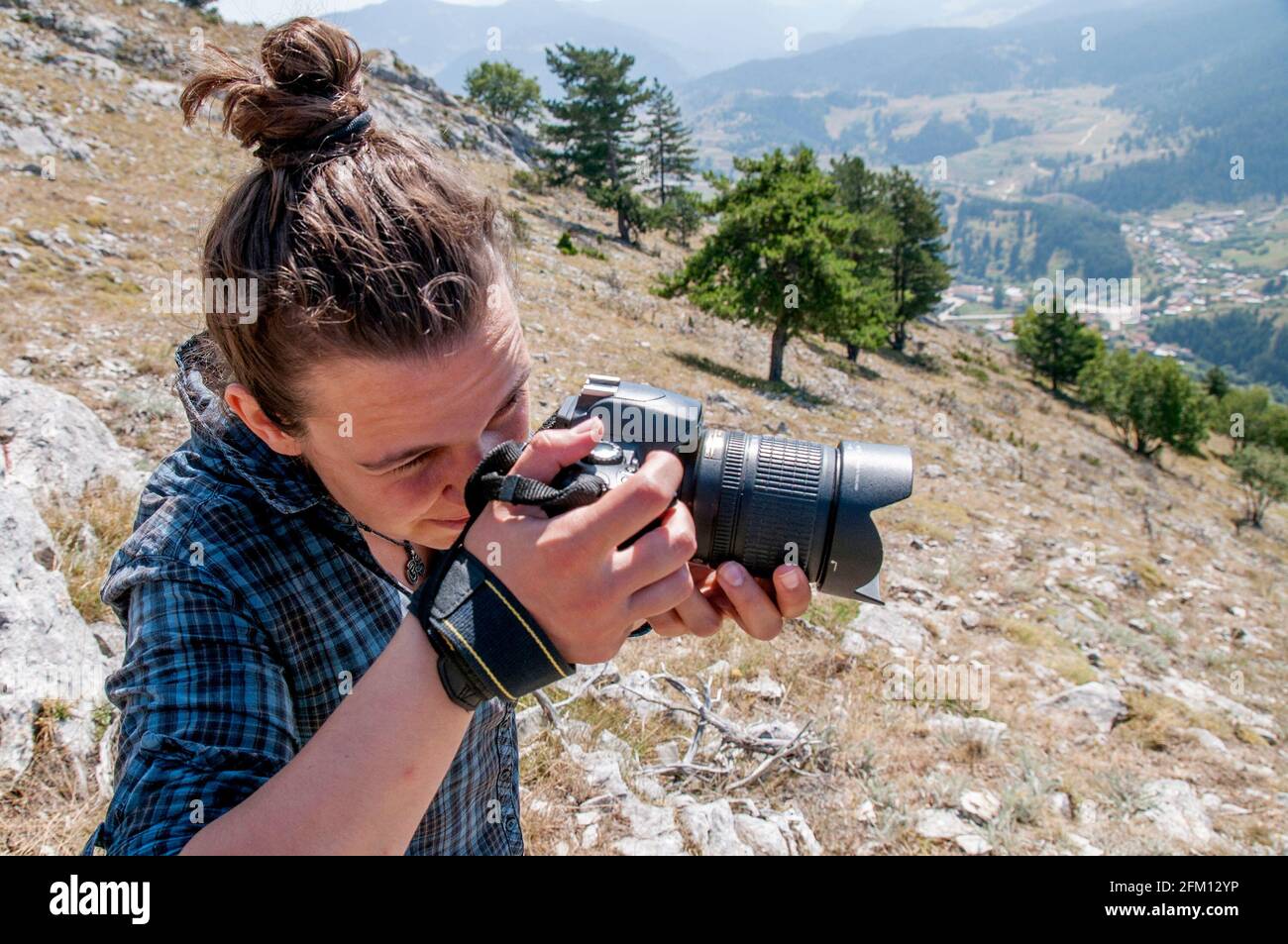 A young woman taking a photo on a mountain. Lifestyle blogging / vlogging about healthy living, nature and outdoors. Stock Photo