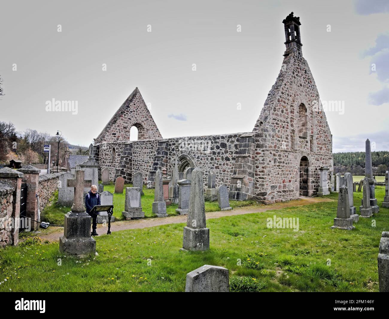 Front view of the old Kincardine O'Neil ruined Kirk with lady reading