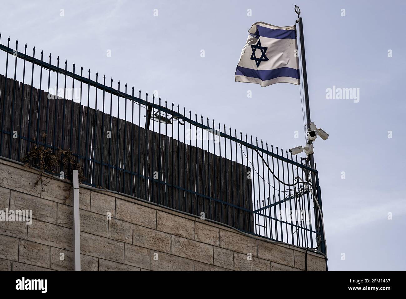 Jerusalem, Israel. 5th May, 2021. The Israeli flag, a fence and security cameras atop a Jewish home in the predominantly Muslim neighborhood of Silwan in east Jerusalem. Credit: Nir Alon/Alamy Live News Stock Photo