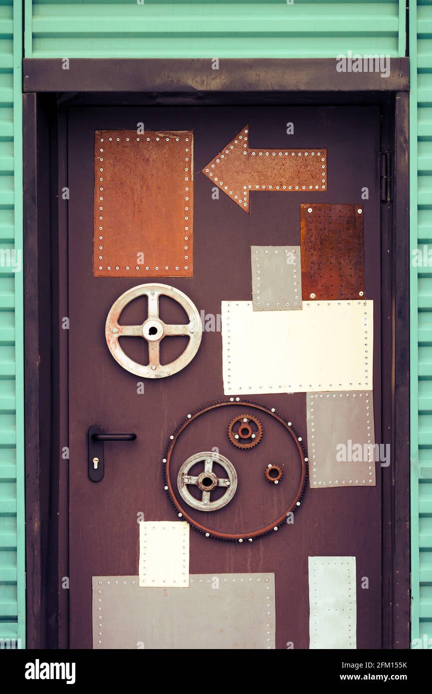 Vintage metal door decorated with arrows and gears Stock Photo