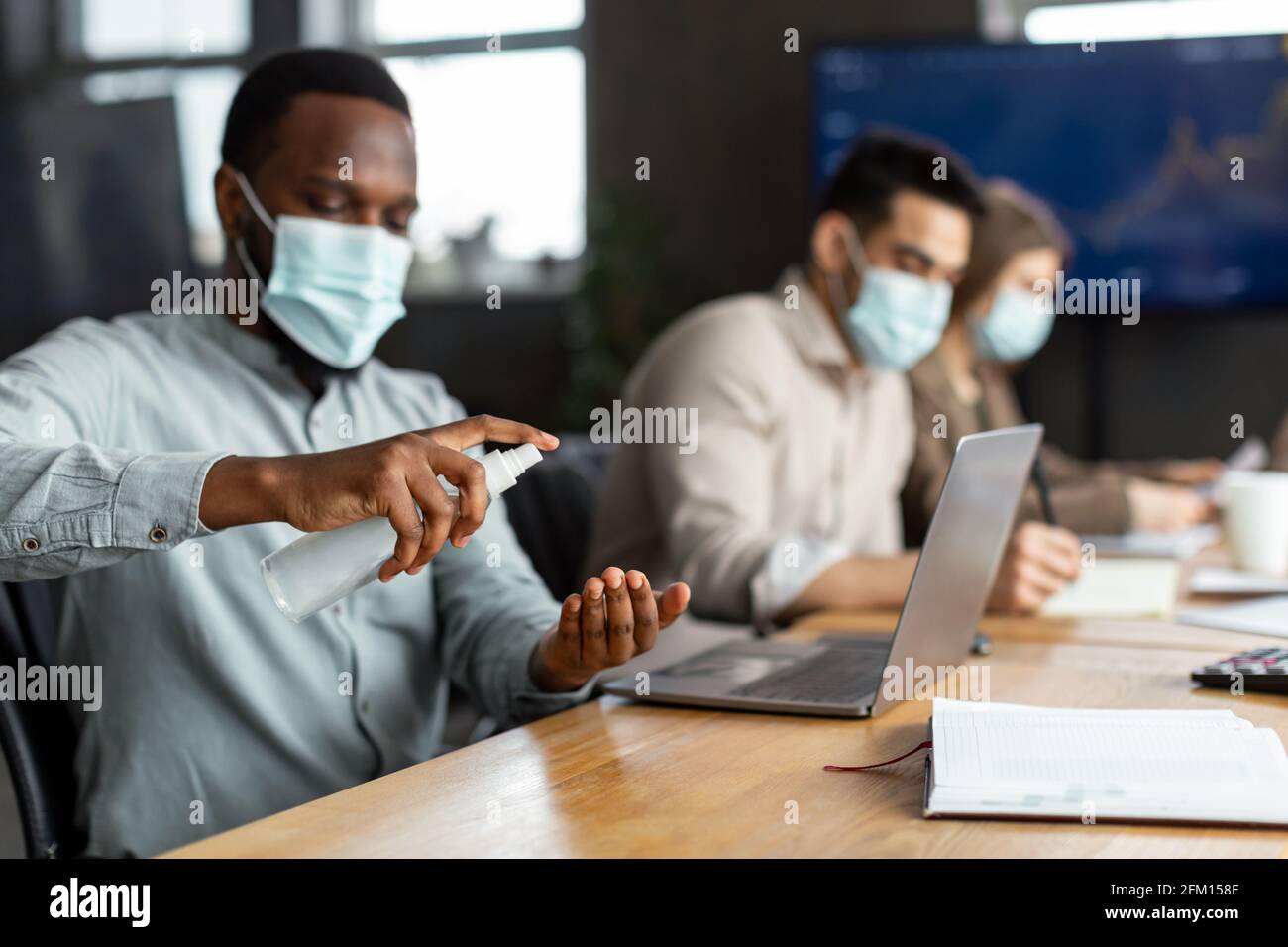 International workers wearing medical masks using sanitizer Stock Photo ...