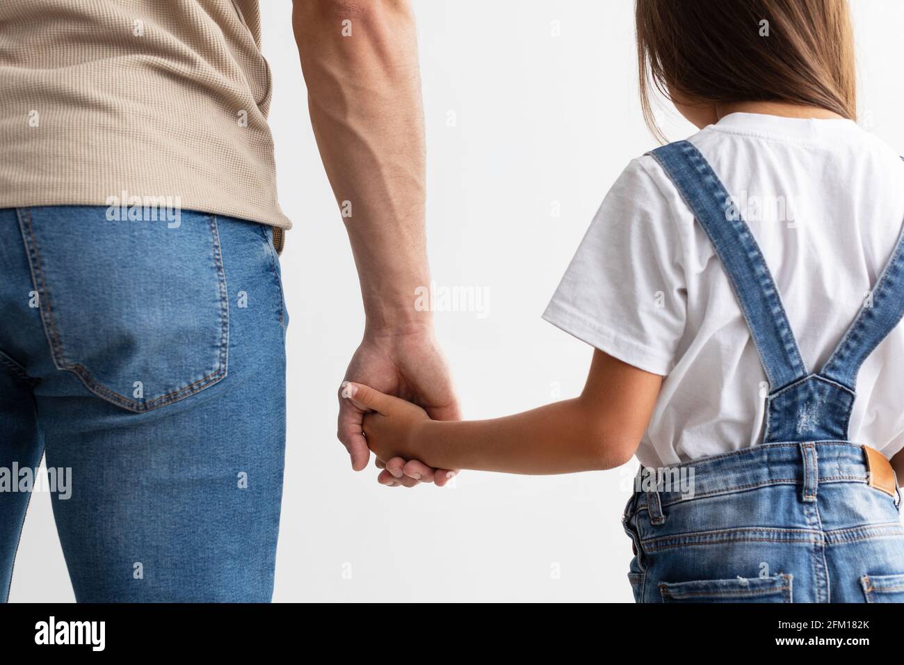 Closeup of father and daughter holding hands Stock Photo - Alamy