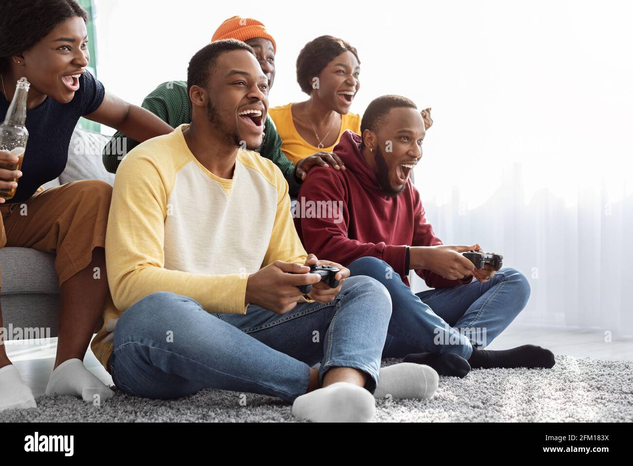 Emotional african american friends playing video games at home Stock Photo  - Alamy