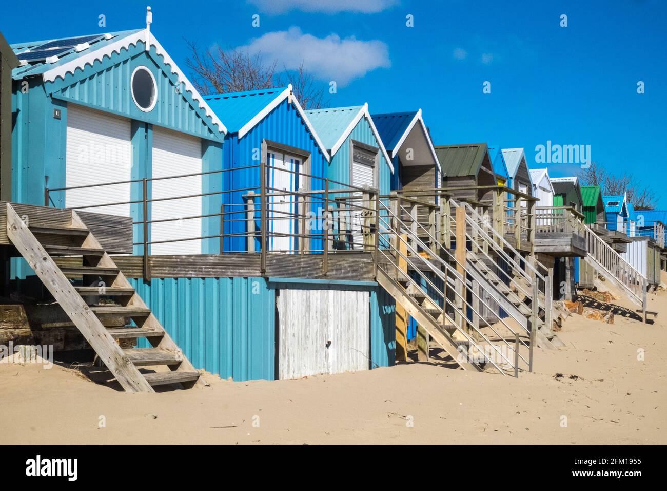 Abersoch Beach in April,out of season,empty beach,beaches,and,closed,beach huts,Abersoch,Llyn Peninsula,Gwynedd,North Wales,Wales,Welsh,Europe.  In Abersoch, a coastal village on the Llŷn Peninsula, about 39% of homes are second homes.Welsh village dubbed 'Cheshire-by-the-Sea' because number of holiday homes snapped up by wealthy owners.families have been priced out by people snapping up coastal properties for second homes Stock Photo