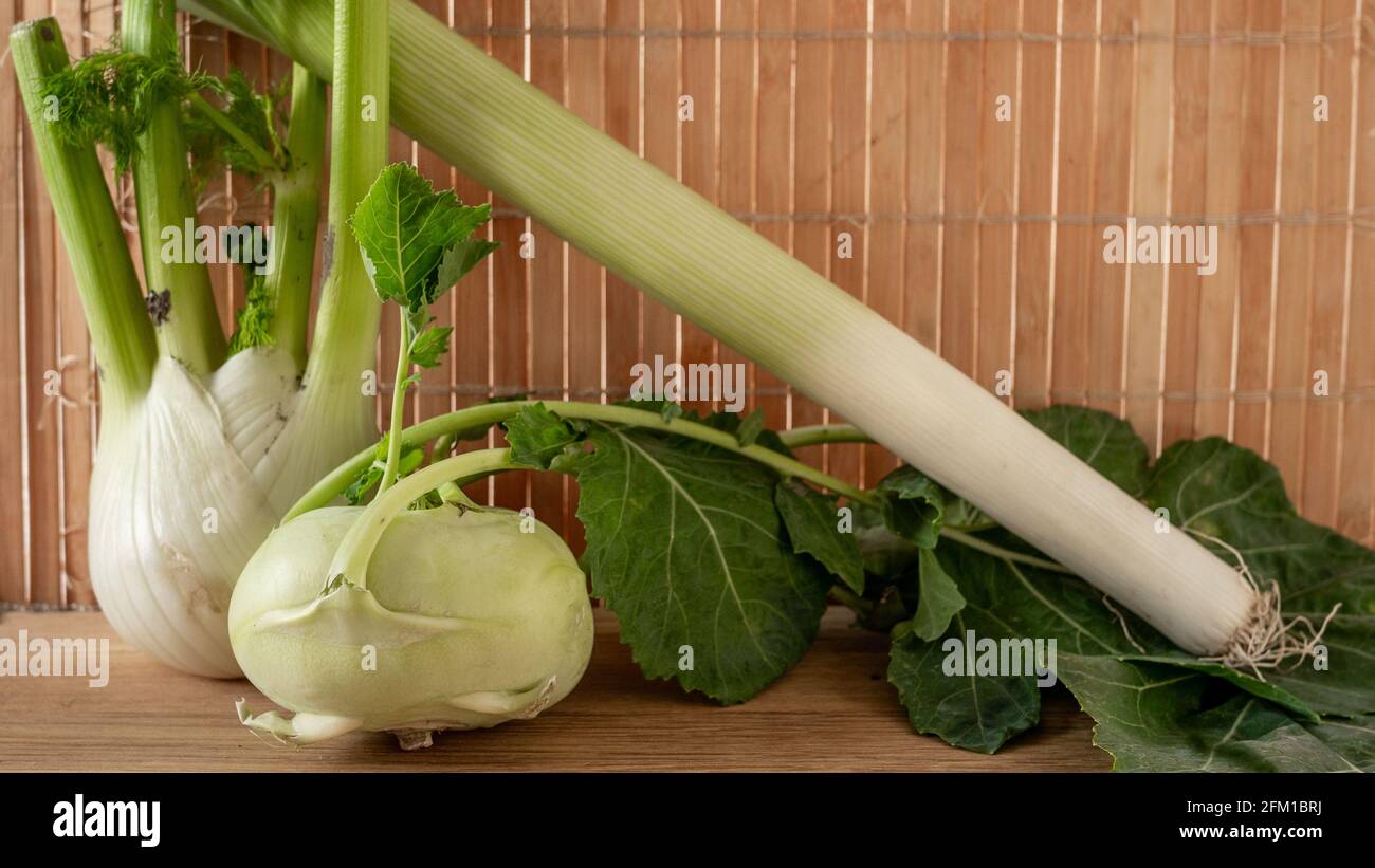 Green vegetables: fennel, beans, kohlrabi against bamboo placing mat background. Clean eating. Close up. Stock Photo