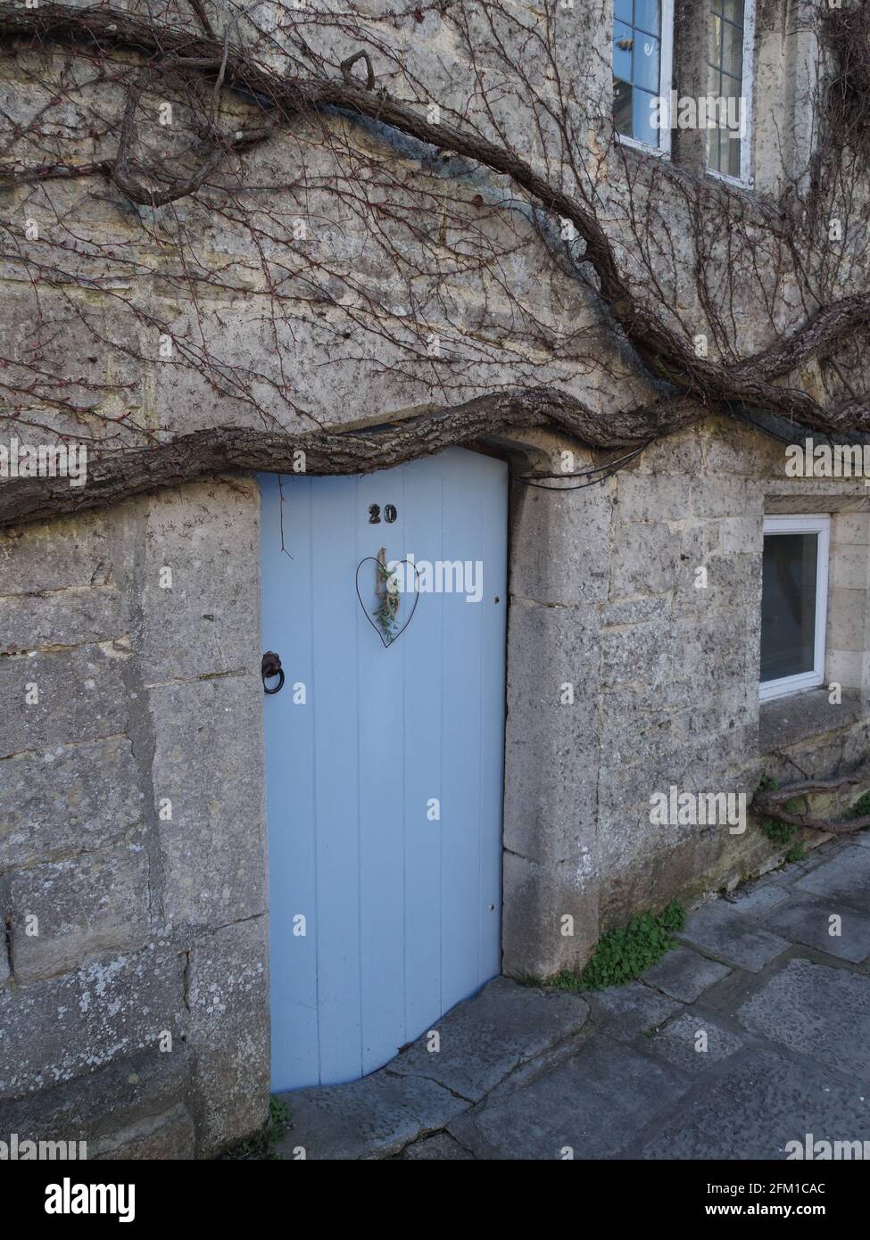 an elegant old stone cottage with a light blue door Stock Photo - Alamy