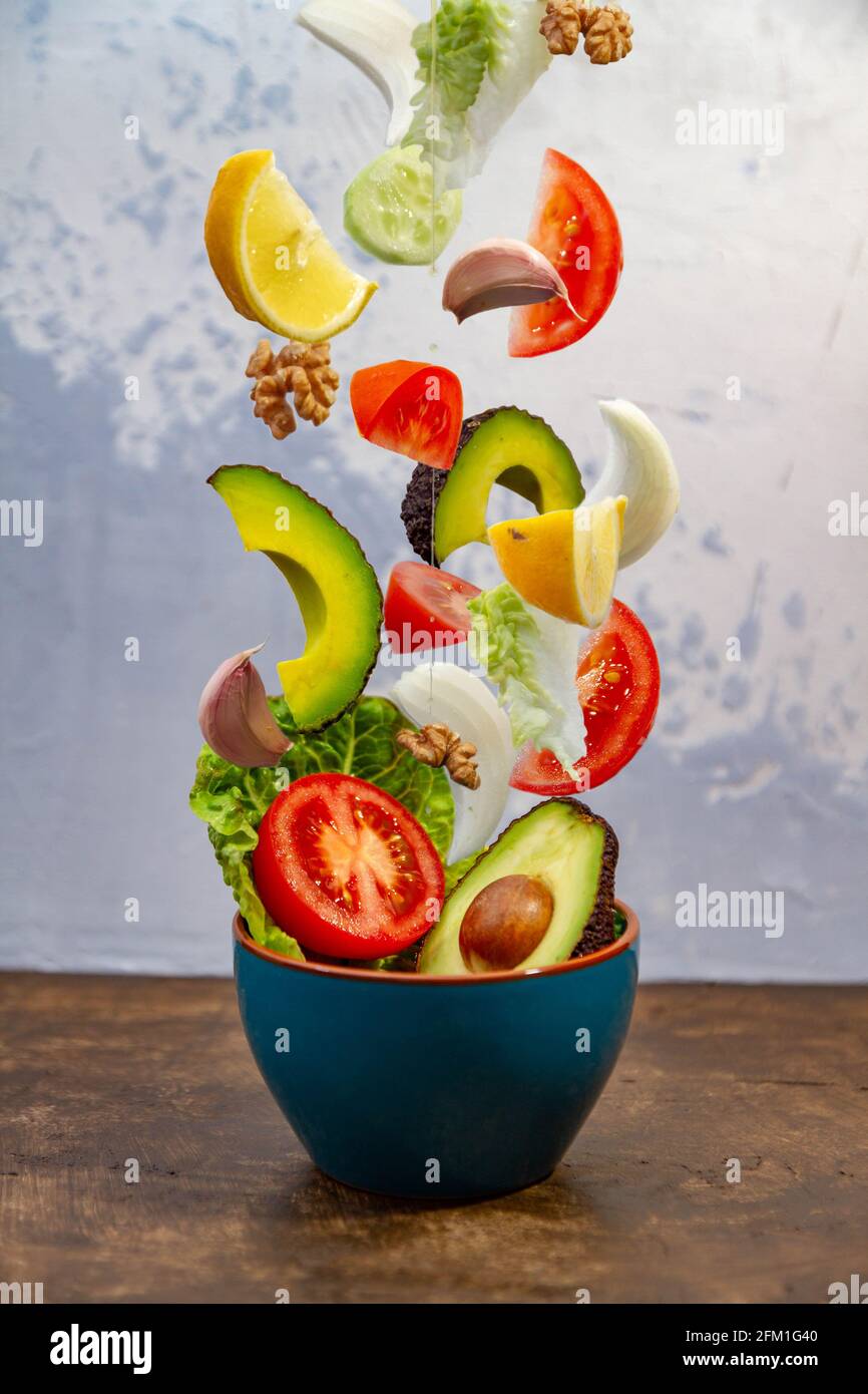 Vertical shot of jumping fruits and vegetables from a blue pot Stock ...