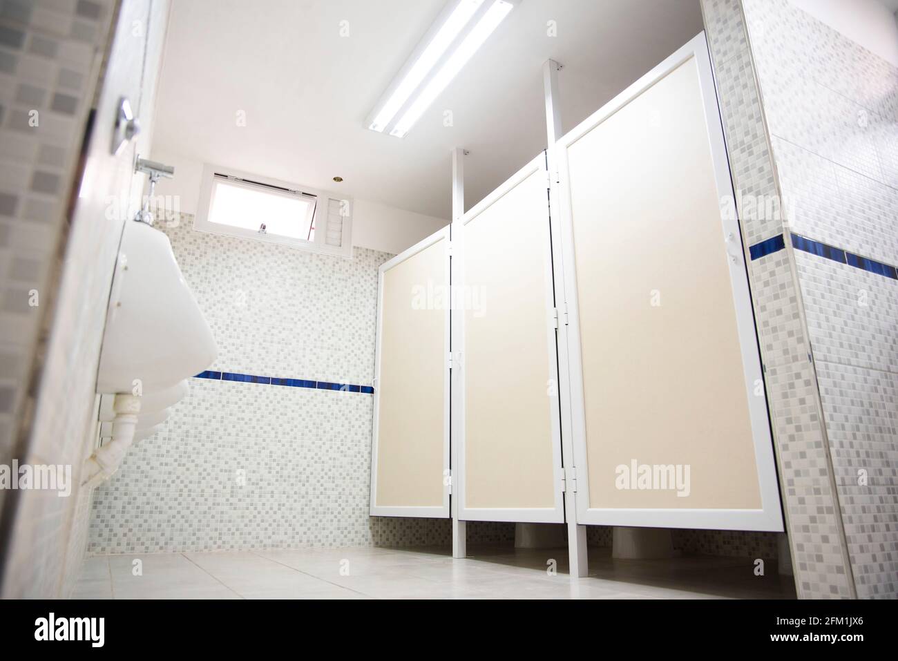 Modern prívate school bathroom, with new tiles, sink, toilette paper. Stock Photo