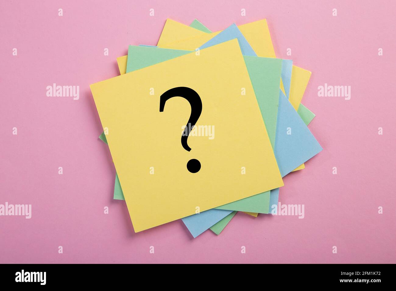 Question mark drawn on notepad. Over pink background with copy space. Stock Photo
