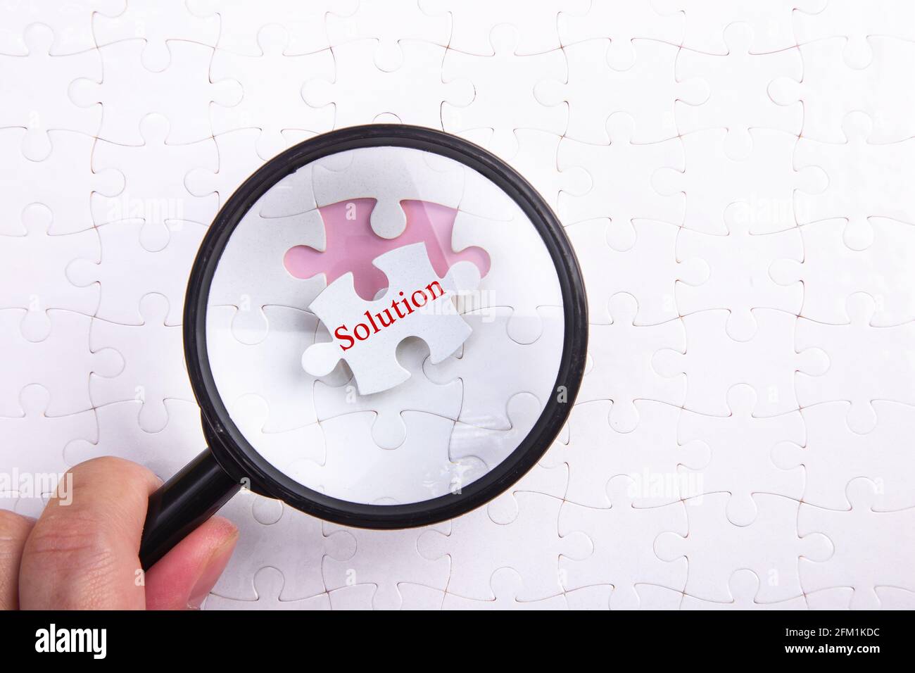 Magnifying glass over jigsaw puzzle Solution Stock Photo Alamy