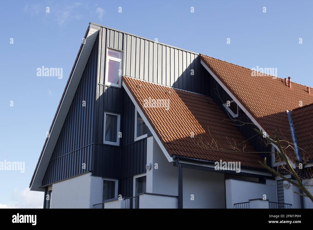 Modern roof house design with red tiles against clear blue sky Stock Photo