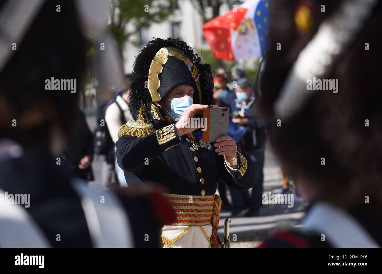 *** STRICTLY NO SALES TO FRENCH MEDIA OR PUBLISHERS - RIGHTS RESERVED ***May 05, 2021 - Paris, France: A reenactor dressed as French emperor Napoleon takes a picture with his smartphone. He wears a mask because of the Covid pandemic. Reenactors dressed as soldiers of Napoleon's Grande Armee gathered in front of the Invalides church, where the French emperor's tomb is located, to mark the bicentenary of his death. Stock Photo